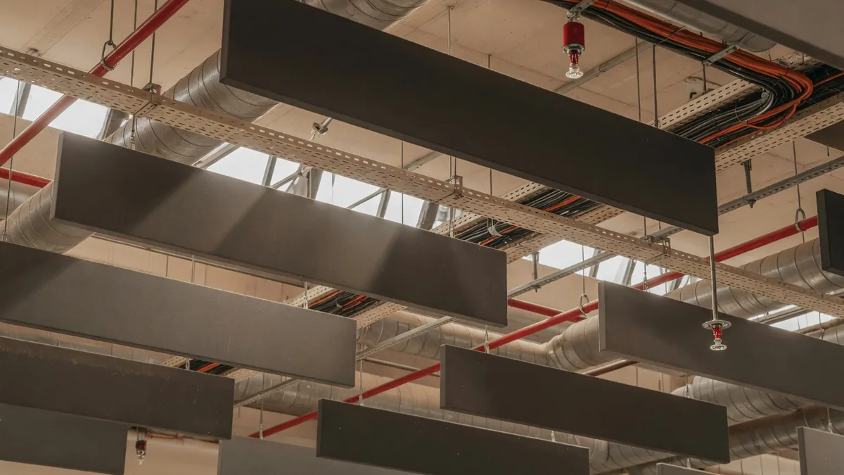 Baffles acoustiques intercalés entre gaines et têtes de sprinklers