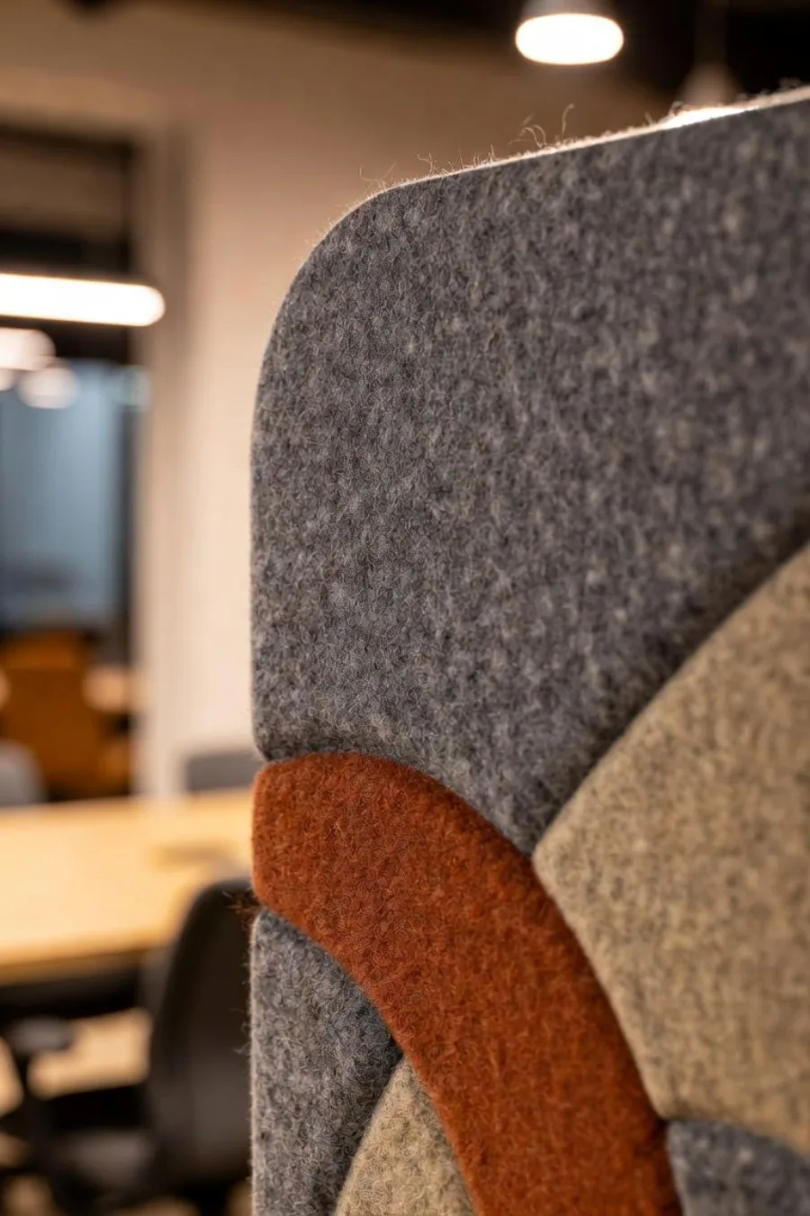 Panneau acoustique imprimé de formes terracotta et sable, au mur d'une salle de réunion